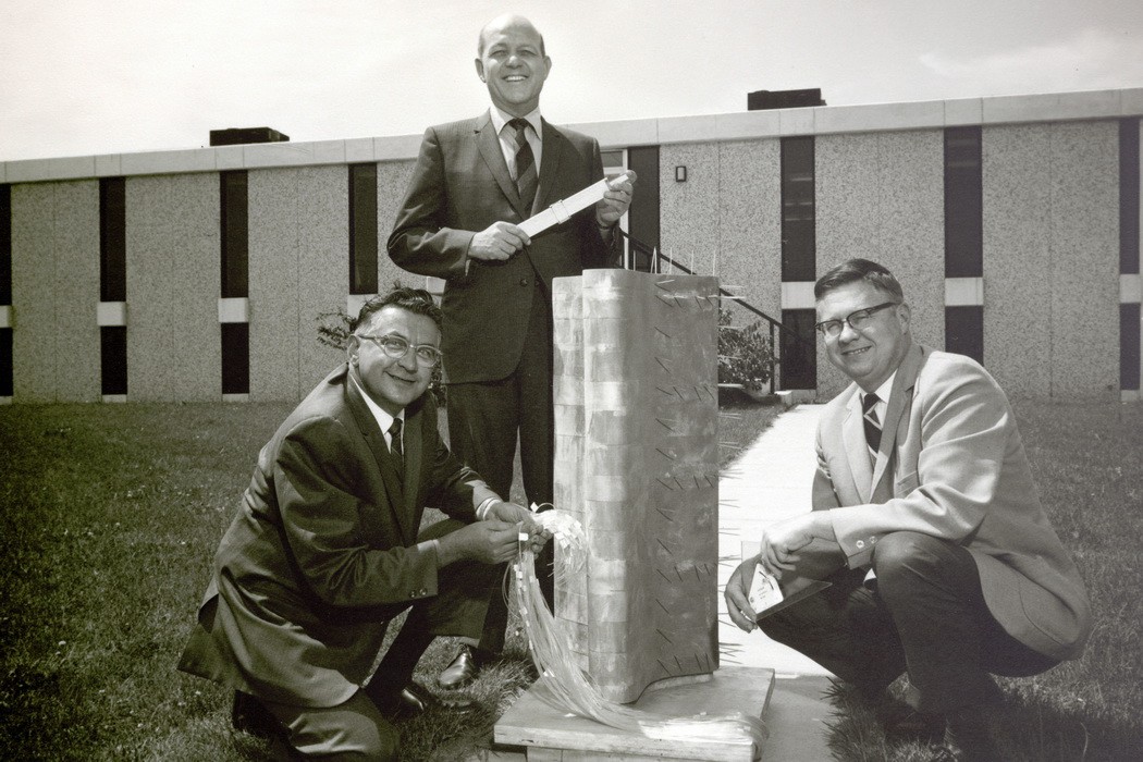 1956–1970: In 1956, a young engineer named Jack Janney accepted a consulting job with the Illinois Tollway Authority to perform full-scale load testing and quality control services for a massive highway construction project using a relatively new product—precast, prestressed concrete girders—Jack's area of research at the Portland Cement Association. Jack sought help from former colleague Dick Elstner and, later, from his neighbor Jack Wiss. Their partnership and passion for problem-solving would endure well beyond that first assignment.